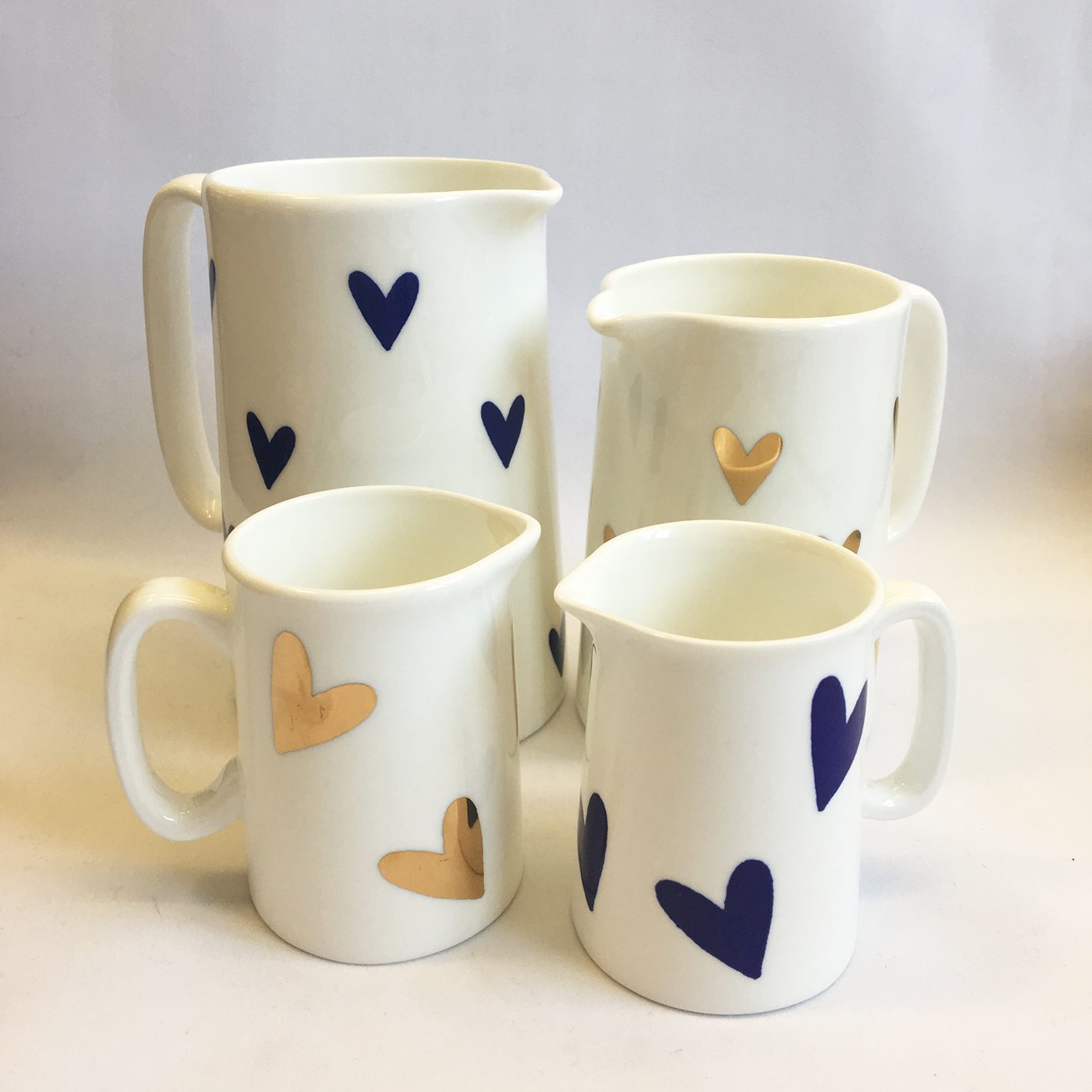 Four jugs printed with gold and blue hearts