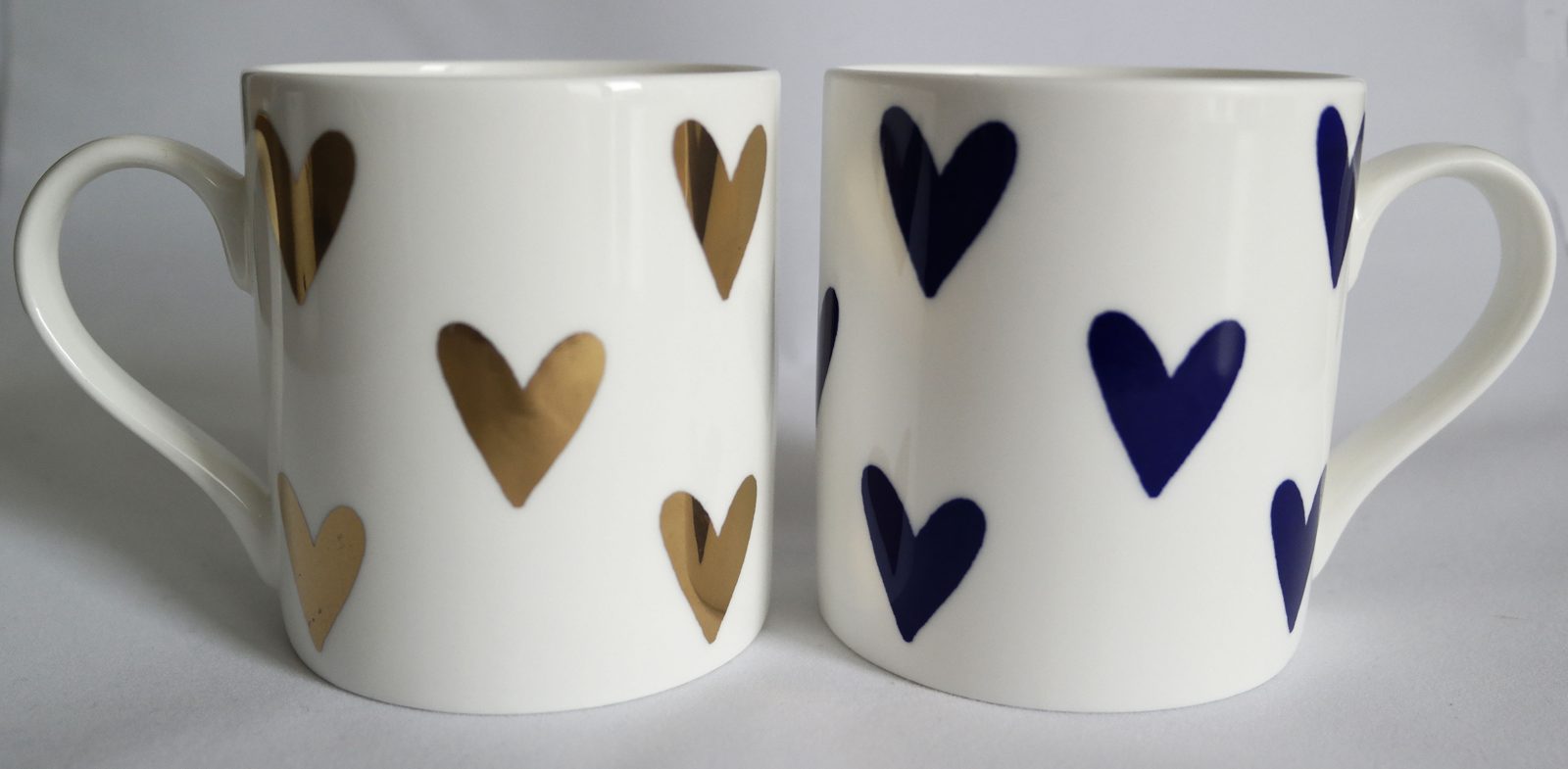 Two mugs screen printed with gold and cobalt blue hearts