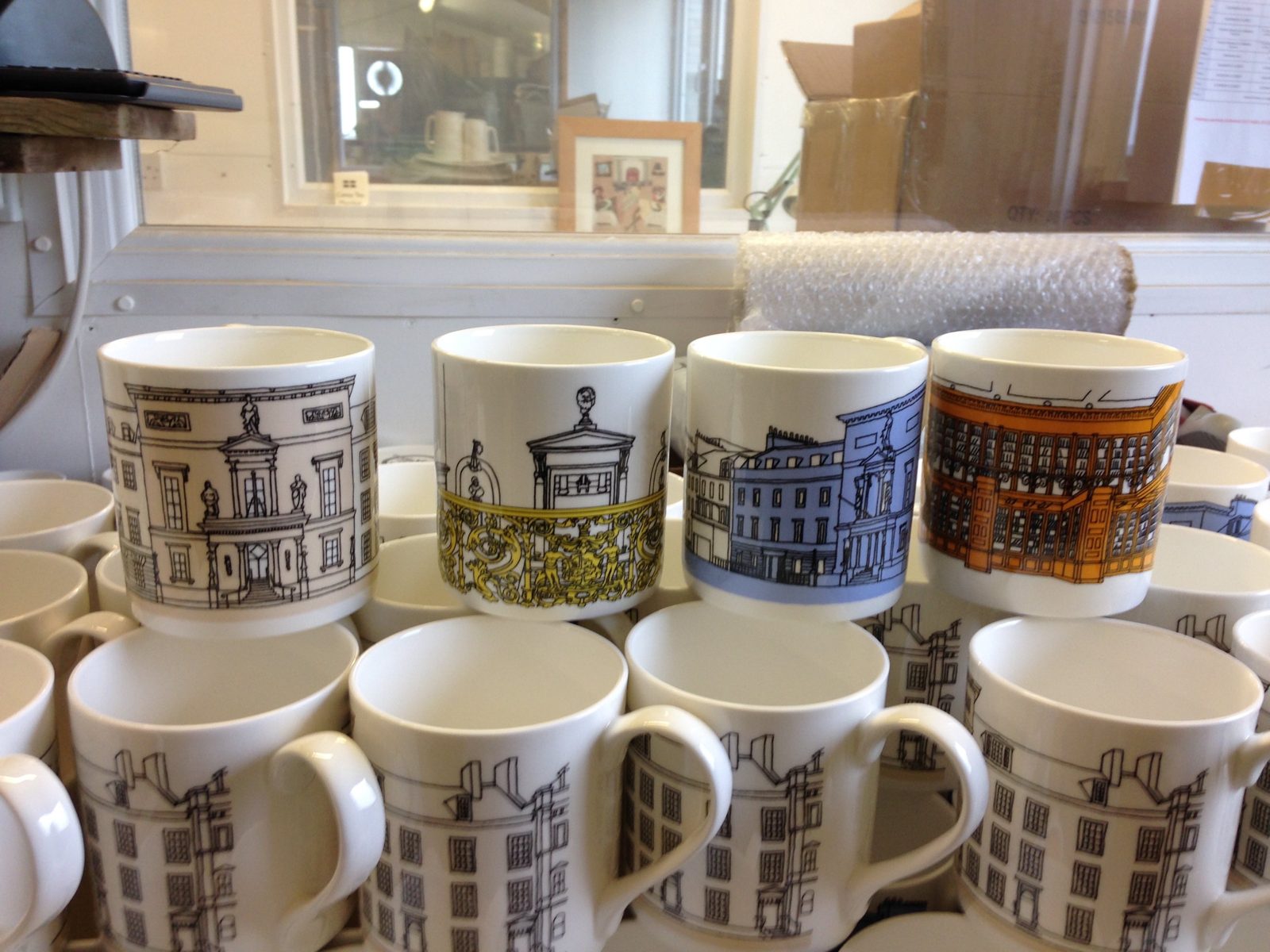 Rows of mugs printed with illustrated buildings