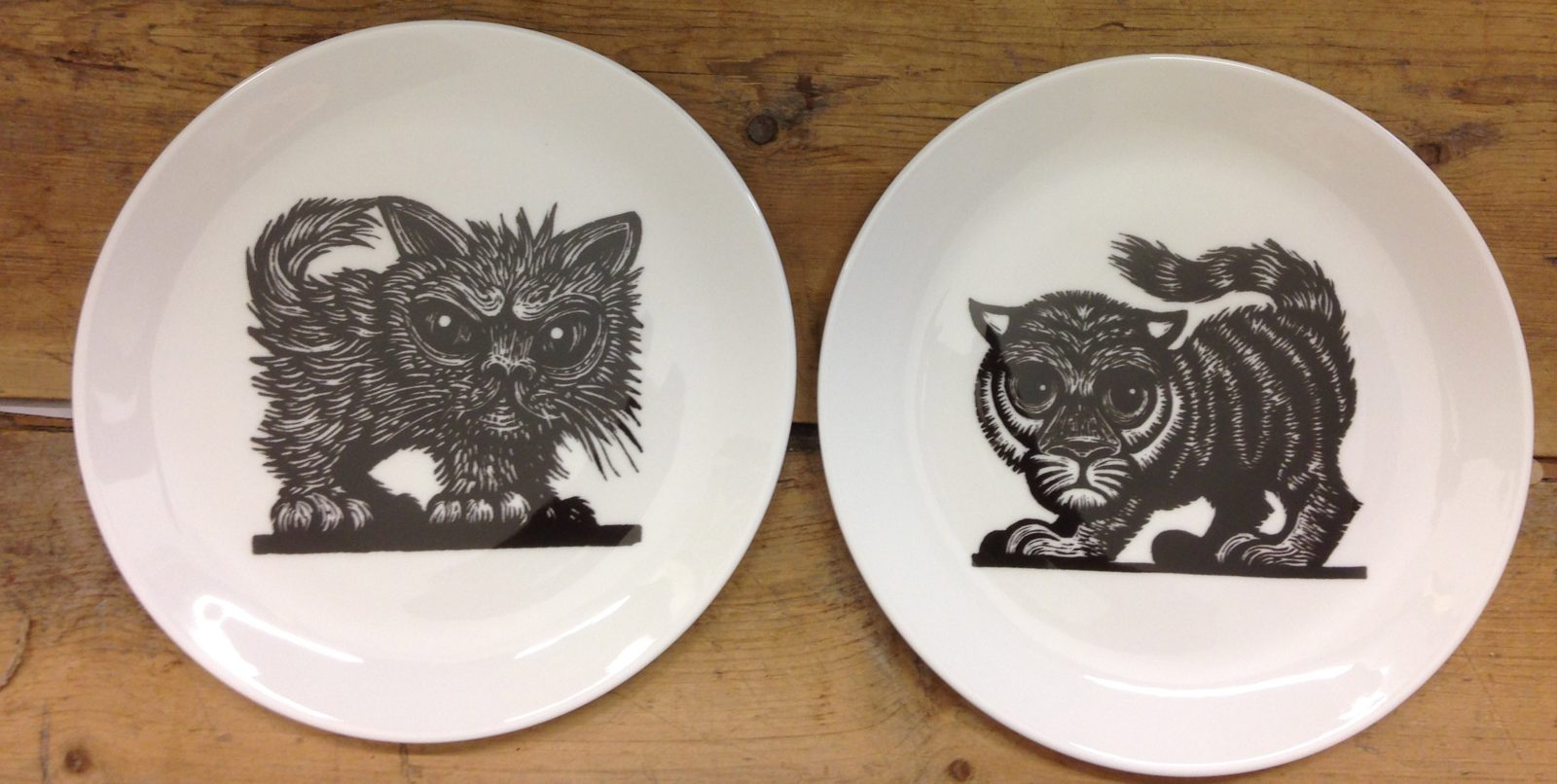 Two plates screen printed with black line drawings of cats